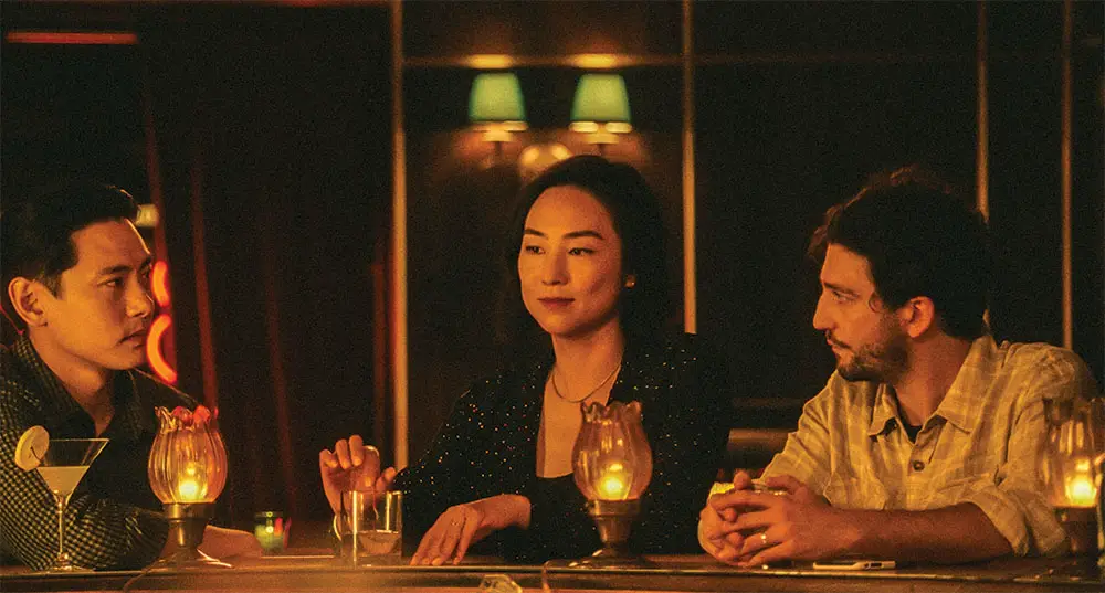De gauche à droite : Yoo, Lee et Magaro dans la scène d'ouverture du film, dans un bar new-yorkais.